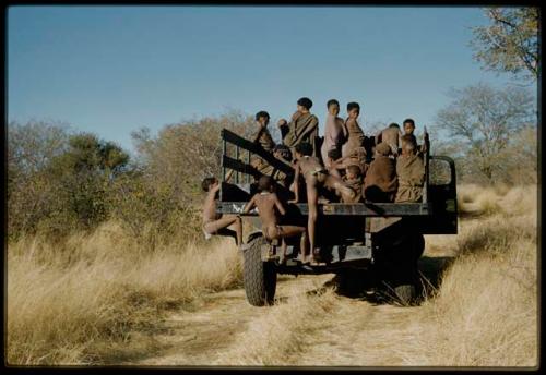 Expedition, Trucks: People standing and sitting in the back of an expedition truck, with more children climbing into it