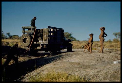 Expedition, Pumping water into trucks: Boys watching an expedition member filling water drums in the back of an expedition truck with water from a waterhole