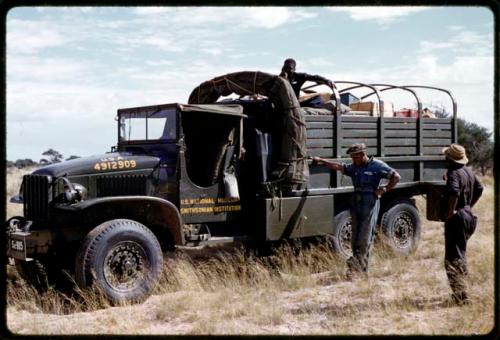 Heinrich Neumann, Kernel Ledimo, and Philip Hameva standing by the GMC expedition truck