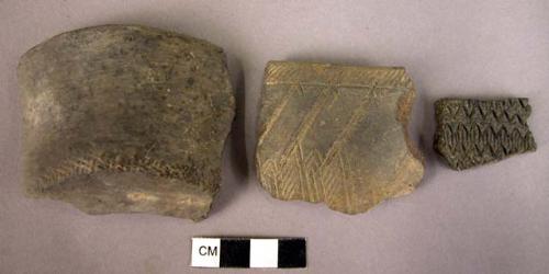 5 gray or black burnished potsherds with incised decoration