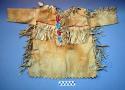 Boy's buckskin shirt. Slit front. Fringed along top of sleeves and sides.