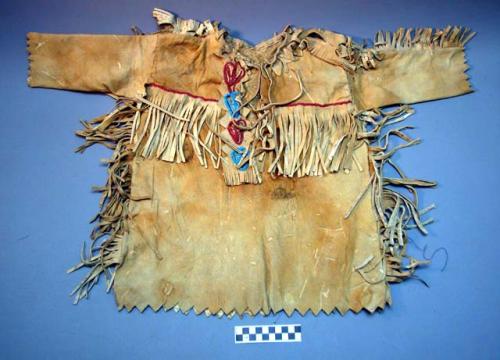 Boy's buckskin shirt. Slit front. Fringed along top of sleeves and sides.