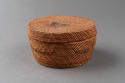 Small cylindrical basket with lid. faded multicolor design of manned boats on bo