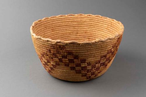 Coiled grass basket with imbricated design; geometric motif