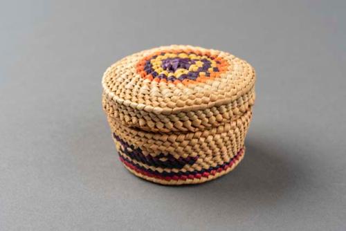 Miniature wrapped twined grass basket (A) with lid (B); geometric motifs