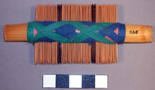 Comb - solid portion between the teeth wound with green & blue thread