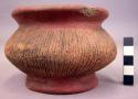 Ceramic, complete jar, ring base, chipped rim, incised sides, red