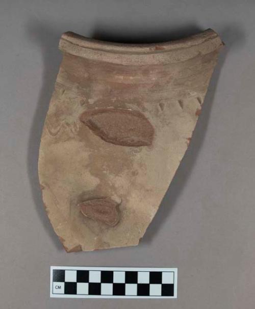 Ceramic, coarse earthenware rim shrd, buff bodied, with indications of broken handle, exterior incised and punctate docaration