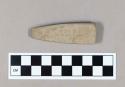 Ground stone object, rectangular, tapered towards one end.