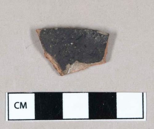 Ceramic, lead glazed redware body sherd, burned on exterior