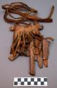 Rattle?, wood crosspiece, pet. wood tied to hide fringe w/sinew, knotted strap