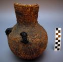 Small basketry water jug, twined. Made of bear grass and covered with pitch.