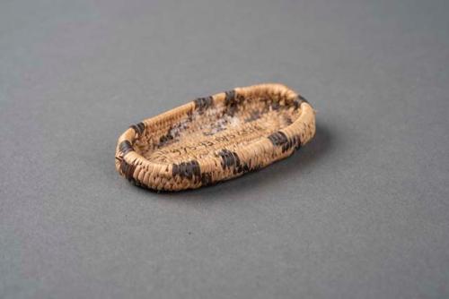 Miniature oblong coiled tray basket, natural with simple black geometric design.