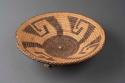 Coiled circular open weave tray of cattail reed with hook motif