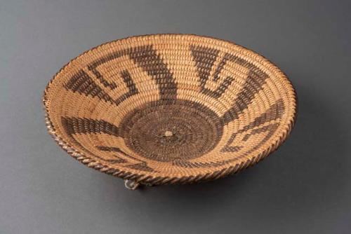 Coiled circular open weave tray of cattail reed with hook motif