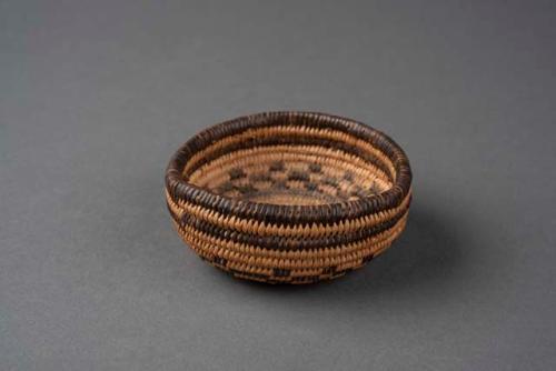 Miniature coiled bowl-shaped basket with checkerboard motif