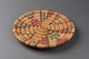 Basket, coiled plaque, red, green, black, natural, damaged center