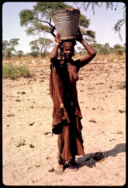 Woman holding a bucket of water on her head