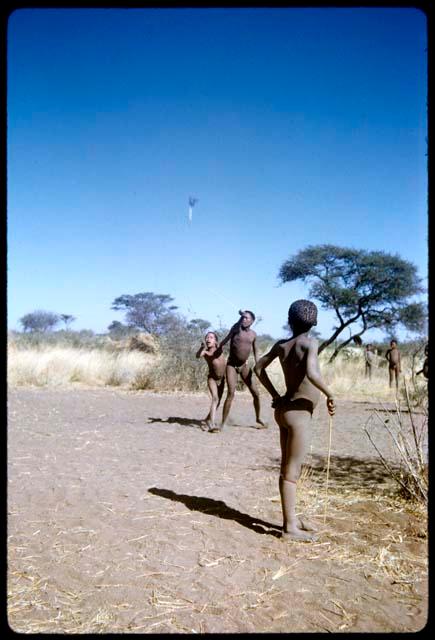 Children, Toys: Children playing the djani (helicopter toy) game, with the djani in the air