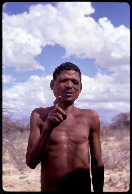 !Kxam demonstrating hunting hand signal for 'kudu'