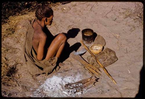 //Kuǂtera sitting, with her possessions on the ground in front of her