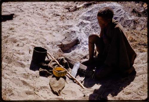 //Kuǂtera sitting, with her possessions on the ground in front of her