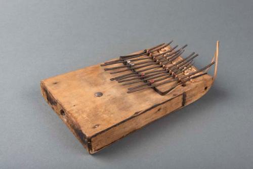 Thumb piano; carved wood body; metal keys & supports; metal tack; perf'd