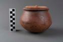 Terracotta container and lid, one of a group of two.