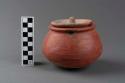 Terracotta container and lid, one of a group of two.