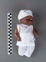 Plastic doll, one of a pair of twins wearing Santeria-Vodou white clothes