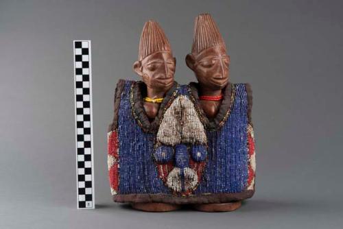 An engraved and carved sculpture depicting Ibeji twins