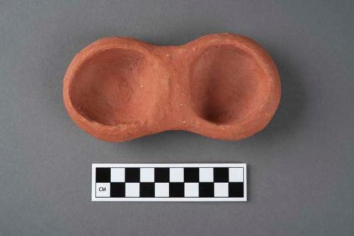 Terracotta object indicating enduring union of twins, one of a group of two.