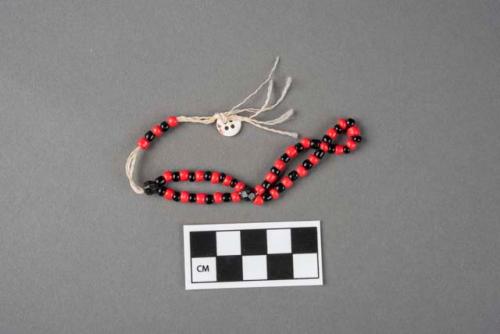 Bracelet strung with plastic corals, one of a group of seven.