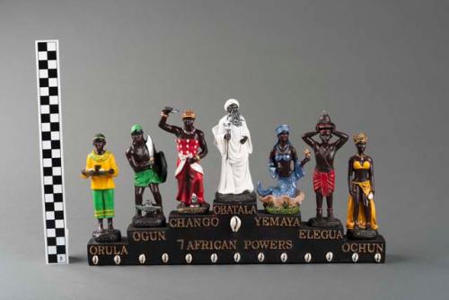 Resin statuette of a group of seven figures identified as the "Seven African Powers"