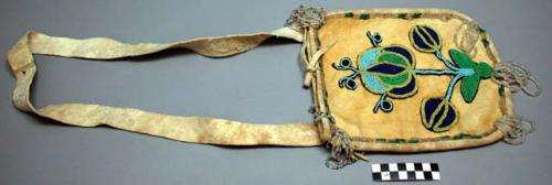 Beaded leather bag with carrying strap and floral beadwork.