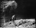 Man walking toward cliff dwelling