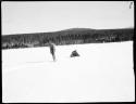 Man dragging a bundle through snow