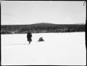 Man dragging a bundle through snow