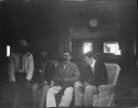 Group of men sitting, in Nukusa