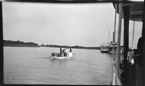 People in a small boat, view from an Irrawaddy Flotilla Company boat