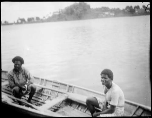 Two men sitting in a boat on shore of the Waidina River