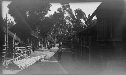 People standing in front of buildings on stilts