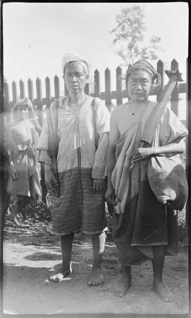 Two people standing in front of a fence