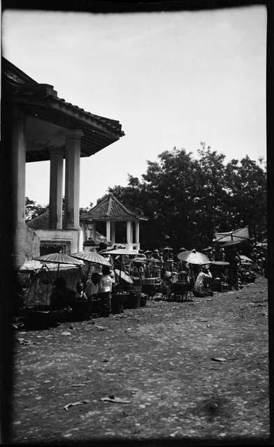 People sitting under umbrellas next to a building