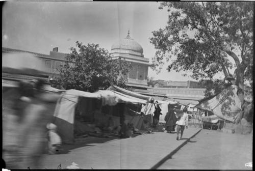 People at a market, with the dome of a building in the background