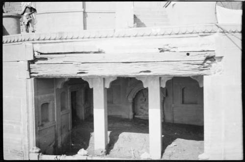 Person standing on the roof of a bulding, over an entrance