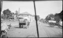 People driving ox carts down a street