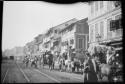 People driving ox carts down a street