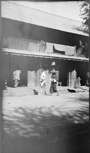 People walking and standing in front of a building