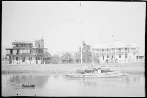 Boat, with buildings along shore in the background